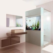 Imagen de cuarto de baño con ducha de puerta transparente y panel lateral con acuario incrustado