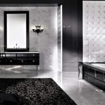 Cuarto de baño en blanco y negro con paredes de mármol, estructuras de cuero y bordes de mármol negro. Bañera y lavabo en mármol negro.